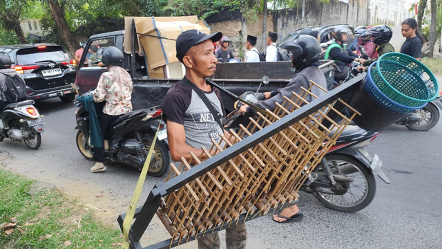 Haris Simanjuntak (40), pria yang memainkan alat musik angklung di persimpangan lampu merah di Medan, Selasa (20/1).  Foto: Amar Marpaung/kumparan