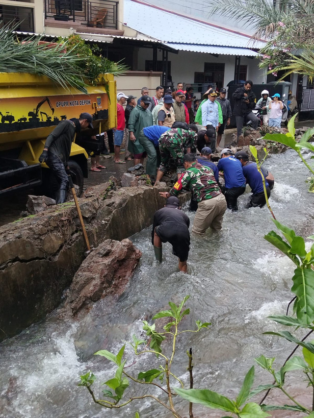 Petugas dan warga memperbaiki Tanggul jebol di wilayah Sukamaju, Depok. Foto: Dok. Pokdar Sukamaju/Istimewa