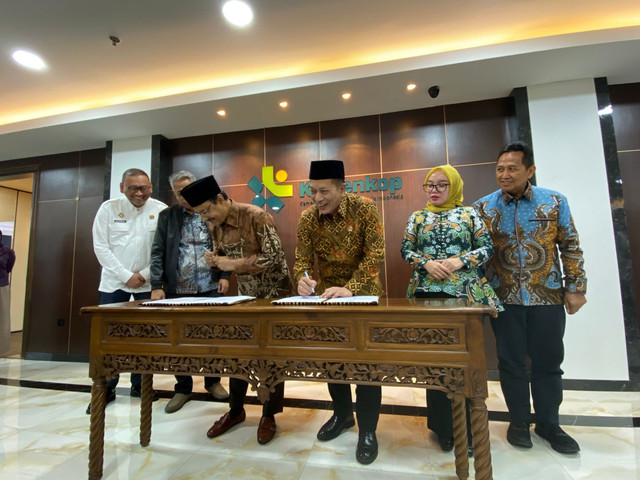 Menteri Sosial Saifullah Yusuf dan Menteri Koperasi Ferry Juliantono menandatangani nota kesepahaman soal PHK jadi anggota Koperasi Desa Merah Putih Foto: Muhammad Fhandra Hardiyon/kumparan
