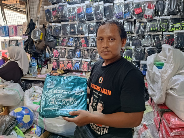 Roni (32), salah satu pedagang jas hujan dan payung di Pasar Asemka, Jakarta Utara, Jumat (23/1). Foto: Ryan Iqbal/kumparan