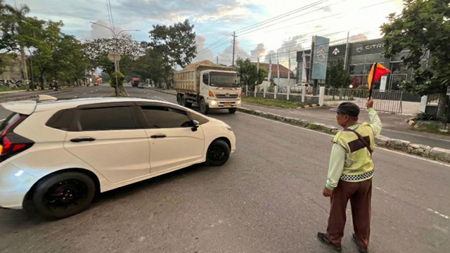 Aksi seorang "Pak Ogah" di Jalur Cepat: Bertaruh nyawa menjaga ketertiban di bawah terik matahari Ring Road Selatan Jogja. (Sumber Foto: Dokumentasi Pribadi)