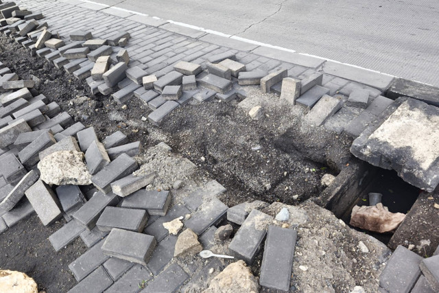 Paving block trotoar terlihat hancur berantakan akibat dugaan aksi pencurian kabel Penerangan Jalan Umum (PJU) di jalan Kramat Jaya, Koja, Jakarta Utara, Minggu (25/1/2026). Foto: Jeni Ritanti/kumparan