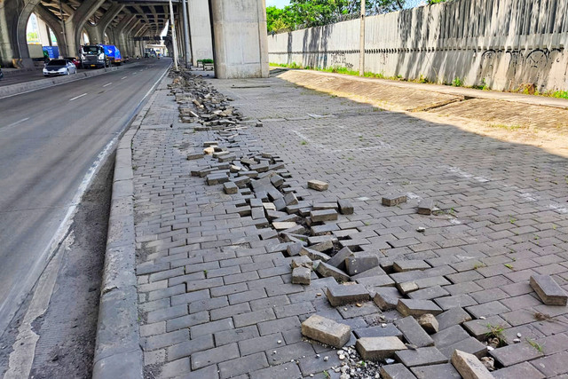 Paving block trotoar terlihat hancur berantakan akibat dugaan aksi pencurian kabel Penerangan Jalan Umum (PJU) di jalan Kramat Jaya, Koja, Jakarta Utara, Minggu (25/1/2026). Foto: Jeni Ritanti/kumparan