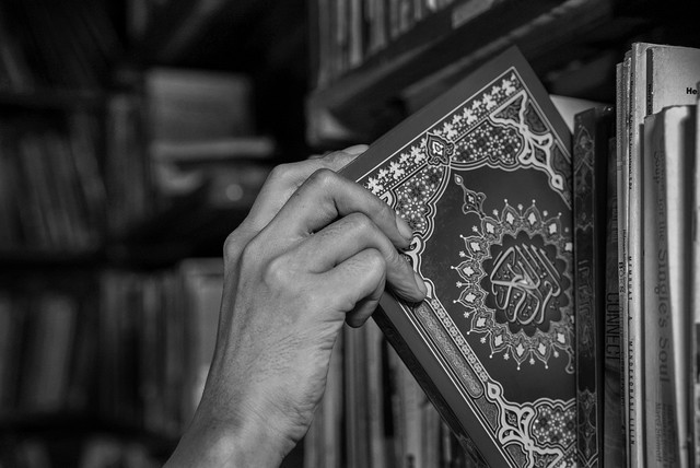 Seorang muslim yang sedang mengambil Al-Qur'an untuk dibaca. Foto: Pixabay