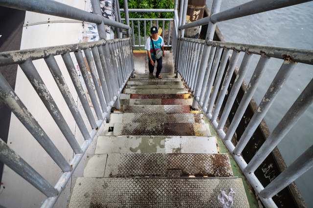 Warga melintasi Jembatan Penyeberangan Orang (JPO) Sahabat di Jalan Daan Mogot, Jakarta Barat, usai mendapat perbaikan setelah kondisi kerusakannya ramai diperbincangkan di media sosial. Foto: Iqbal Firdaus/kumparan
