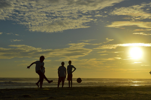 Anak-anak bermain sepak bola di pinggir pantai. Foto: Pixabay