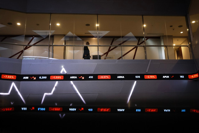 Seorang pria berjalan di atas layar digital pergerakan Indeks Harga Saham Gabungan (IHSG) di Bursa Efek Indonesia (BEI), Jakarta, Rabu (28/1/2026). Foto: Dhemas Reviyanto/ANTARA FOTO