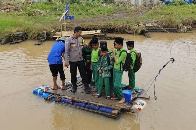 Sejumlah anak sekolah menaiki getek saat menyeberangi Kali Beringin di Kecamatan Tugu, Kota Semarang, Rabu (28/1/2026). Foto: Intan Alliva Khansa/kumparan