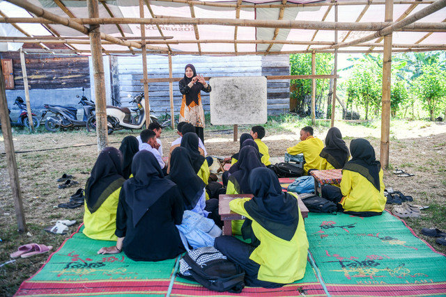 Seorang guru memberikan materi pelajaran di sekolah darurat gabungan PAUD, SD dan SMP di Balai Desa Agusen, Blangkejeren, Kabupaten Gayo Lues, Aceh, Kamis (29/1/2026). Foto: Raisan Al Farisi/ANTARA FOTO