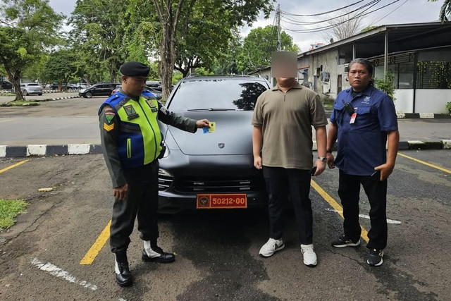 Petugas mengamankan kendaraan yang menggunakan plat nomor dinas Kemhan di area Parkir Bandara Halim Perdanakusuma, Jakarta, Rabu (28/1/2026). Foto: Instagram/@Kemhanri