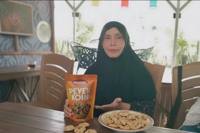 Nasabah PNM Mekaar asal Bogor, Murni berhasil mengembangkan usaha Peyek Koin setelah bertemu dan mendapat pendampingan dari petugas lapangan. Foto: Dok. PNM