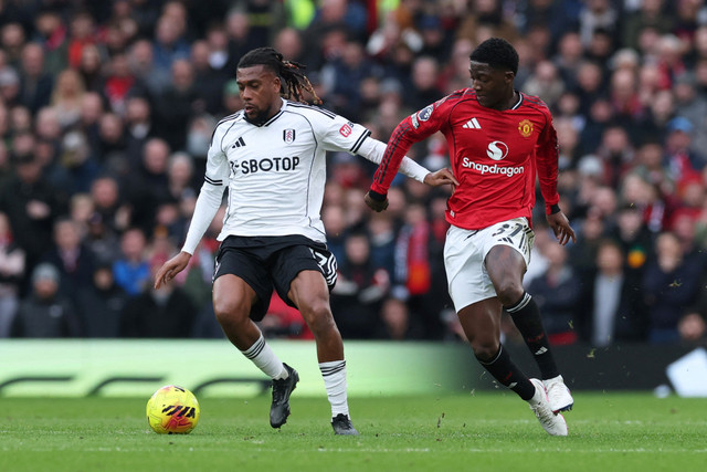 Pemain Manchester United Kobbie Mainoo berebut bola dengan pemain Fulham Alex Iwobi pada pertandingan Liga Inggris di Old Trafford, Manchester, Inggris, Minggu (1/2/2026). Foto: Phil Noble/REUTERS