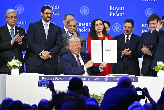 President Donald Trump holds a signing founding charter at the Board of Peace meeting Thursday in Davos, Switzerland. (AFP/Fabrice Coffrini)
