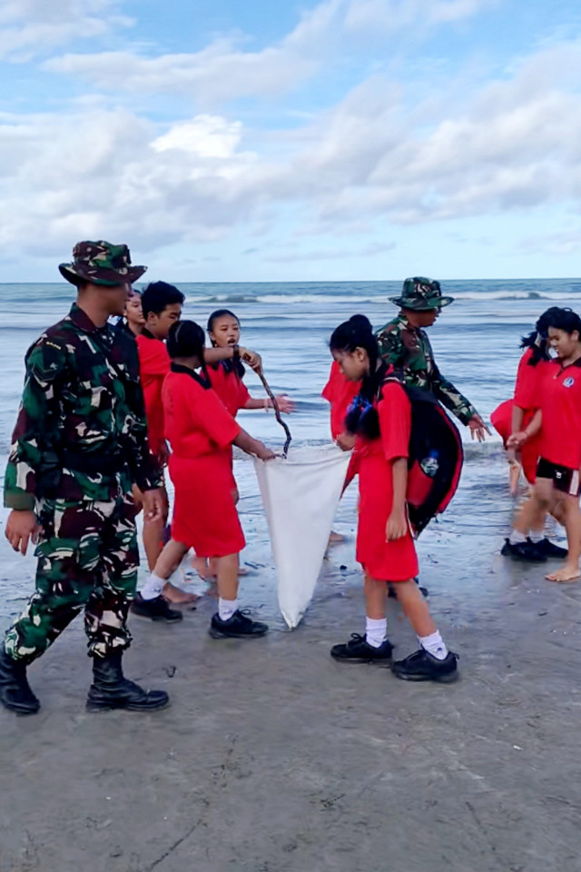 Anggota TNI bersama anak-anak sekolah melaksanakan aksi gotong royong membersihkan sampah di sekitar Pantai Kuta, Bali, Selasa pagi (3/2/2026). Foto: Dok. Bakom RI