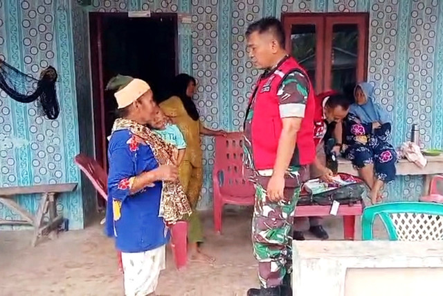 Petugas medis dari personel Tentara Nasional Indonesia (TNI) mendatangi warga untuk memeriksakan kesehatan dan memberikan pelayanan pengobatan di wilayah terdampak bencana banjir bandang. Foto: Dok. Bakom RI