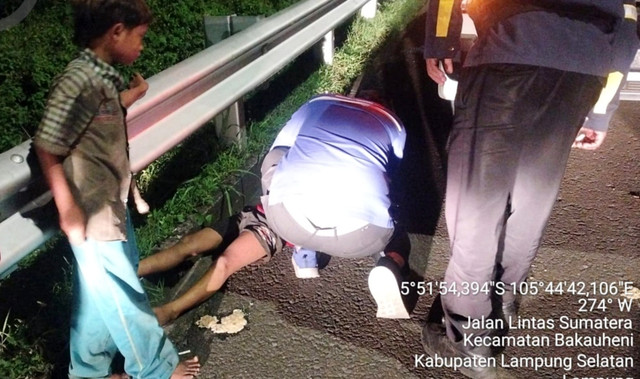 Dua bocah yang diduga melompat dari truk fuso bermuatan excavator ditemukan di pinggir Jalan Tol Trans Sumatera (JTTS) KM 00+800 A, Kecamatan Bakauheni, Kabupaten Lampung Selatan. Foto: Dok. Tol HKA