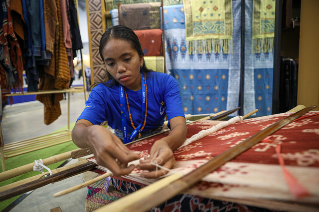 Pengrajin kain tenun saat memeraktikan pembuatan tenun di pameran BCA Expoversary 2026 yang diselanggrakan di ICE BSD, Tangerang, Jumat (6/2/2026). Foto: Aditia Noviansyah/kumparan