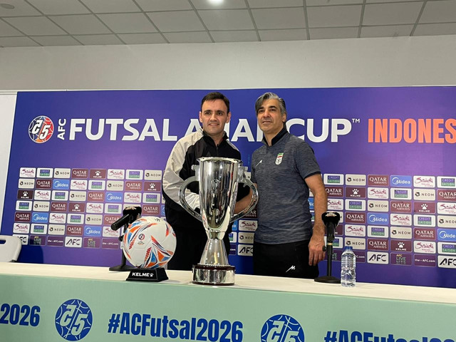 Pelatih Timnas Futsal Indonesia, Hector Souto; dan pelatih Iran, Vahid Shamsaei; berpose dengan trofi Piala Asia 2026. Foto: Aji Nugrahanto/kumparan