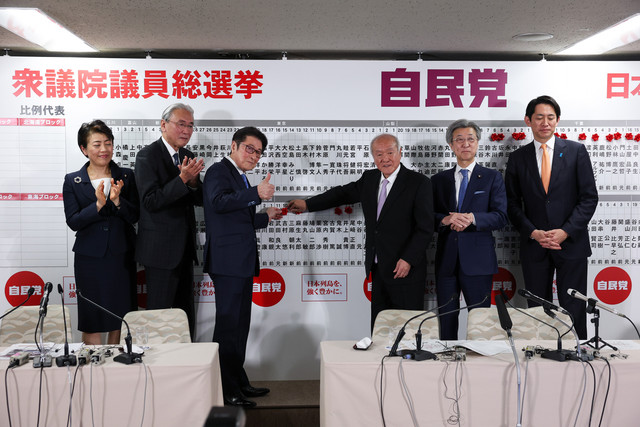Sekretaris Jenderal Partai Demokrat Liberal (LDP) Jepang yang berkuasa, Shunichi Suzuki, dan anggota parlemen lainnya memasang lencana yang menandai nama-nama kandidat yang memenangkan pemilihan majelis rendah di markas besar LDP di Tokyo. Foto: Kim Kyung-Hoon/Pool Photo via AP