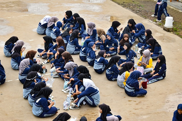 Anak-anak sekolah sedang duduk berbaris bersiap untuk permainan. Sumber foto: unsplash.com