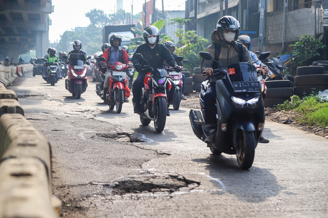 Sejumlah kendaraan tampak melambat dan menghindari jalan yang berlubang saat melintas di Jalan H. Naman, kawasan Pondok Kelapa, Jakarta Timur, Rabu (11/2/2026). Foto: Iqbal Firdaus/kumparan