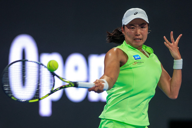 Janice Tjen dari Indonesia memukul bola balasan melawan Iga Swiatek dari Polandia selama pertandingan tunggal putri mereka di turnamen tenis Qatar Open di Doha, Selasa (10/2/2026). Foto: Karim Jaafar/AFP