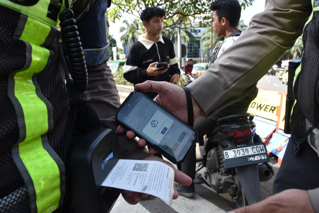 Personel Sat Lantas Polresta Bogor Kota menggunakan alat tilang Electronic Traffic Law Enforcement (ETLE) Mobile pada pelanggar lalu lintas yang tidak menggunakan helm di depan Tugu Kujang, Kota Bogor, Jawa Barat, Rabu (11/2/2026). Foto: Arif Firmansyah/ANTARA FOTO
