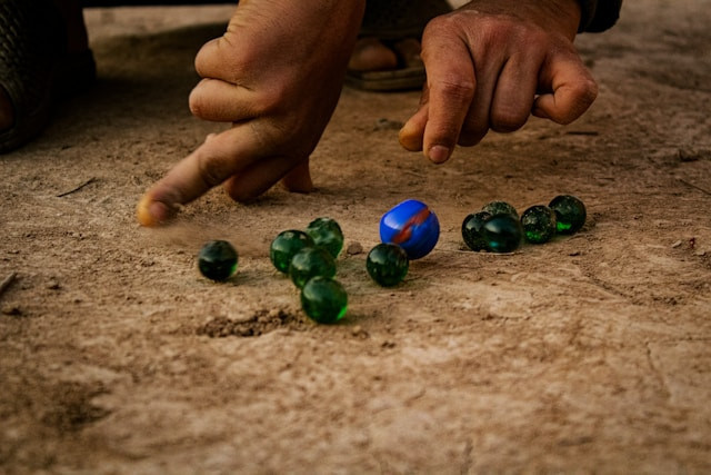 Anak-anak sedang memainkan temeker, kelereng khas Banyuwangi. Sumber foto: unsplash.com