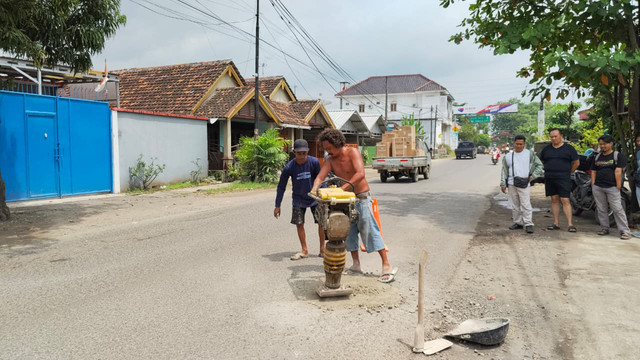 Warga Desa Blaru, Kecamatan/Kabupaten Pati, gotong-royong menambal jalan berlubang di Jalan Pati-Purwodadi, Rabu (11/2/2026). Foto: kumparan