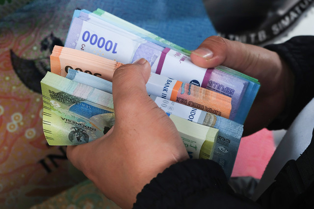 Warga menghitung uang rupiah hasil penukaran di mobil kas keliling Bank Indonesia saat kegiatan Sempurna di halaman Mall Ayani, Pontianak, Kalimantan Barat, Jumat (13/2/2026). Foto: Jessica Helena Wuysang/ANTARA FOTO