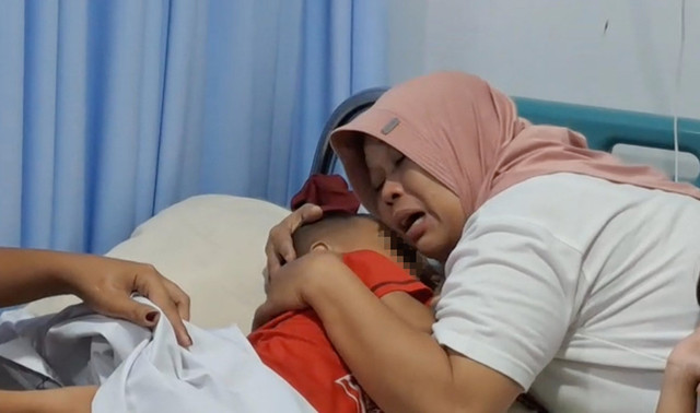 Balita yang disiksa pacar ibunya, saat dipeluk oleh neneknya. Foto: Dok. kumparan