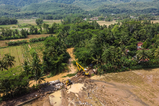 Foto udara pekerja menggunakan alat berat memperbaiki tanggul Sungai Citalahab yang jebol pascabanjir di Desa Bangunsari, Kecamatan Pamarican, Kabupaten Ciamis, Jawa Barat, Selasa (17/2/2026). Foto: Adeng Bustomi/ANTARA FOTO