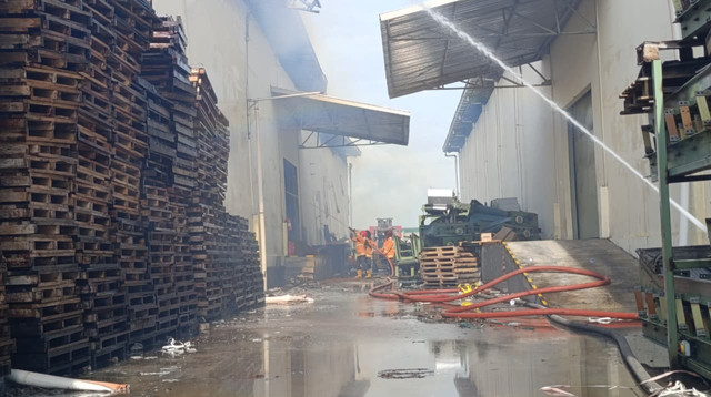 Petugas pemadam kebakaran memadamkan api yang membakar gudang di Desa Gondangmanis, Kecamatan Bae, Kabupaten Kudus, Jawa Tengah pada Rabu (18/2). Foto: Vega Ma'arijil Ula/kumparan