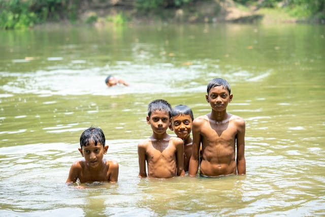 Anak-anak yang dikejar dalam permainan bas-basan sedang berlidung di air setinggi pusar. Sumber foto: pexels.com