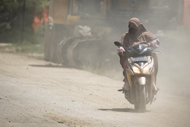 Pengendara sepeda motor menggunakan masker saat melintas di Jalan Lintas Sumatera, Karang Baru, Aceh Tamiang, Aceh, Jumat (20/2/2026). Foto: Aprilio Akbar/ANTARA FOTO