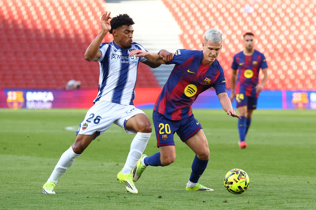 Pemain FC Barcelona Dani Olmo berebut bola dengan pemain Levante Kareem Tunde pada pertandingan Liga Spanyol di Camp Nou, Barcelona, Spanyol, Minggu (22/2/2026). Foto: Albert Gea/REUTERS