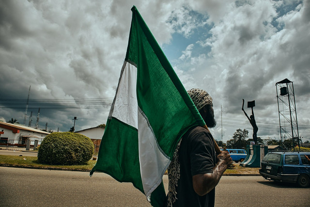 Warga Nigeria memanggul bendera sebagai bagian dari protes pada Oktober 2020. Foto: Emmanuel Ikwuegbu/Unsplash