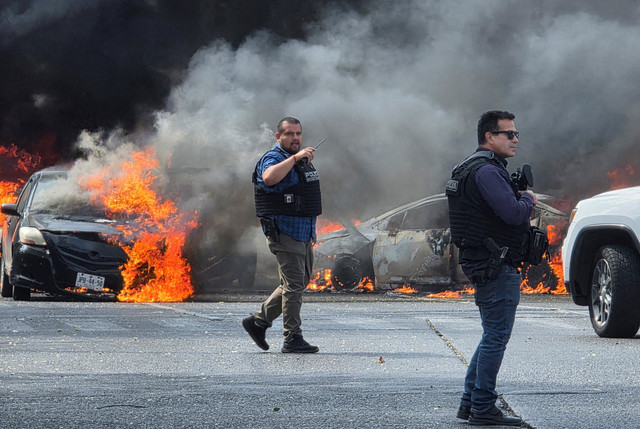 Petugas polisi mengamankan area tempat kendaraan dibakar oleh anggota kejahatan terorganisir untuk memblokir jalan setelah operasi militer di Zapopan, Meksiko, 22 Februari 2026. Foto: REUTERS/Gilberto Gallo 