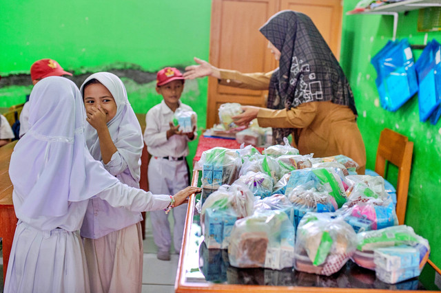 Guru membagikan menu Makan Bergizi Gratis (MBG) kepada siswa di SD Negeri 1 Bojongleles, Lebak, Banten, Senin (23/2/2026). Foto: Muhammad Bagus Khoirunas/ANTARA FOTO