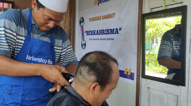 Zainuddin, seorang guru honorer yang sukses menjalankan usaha pangkas rambut di Barito Kuala (Sumber : DT Peduli)