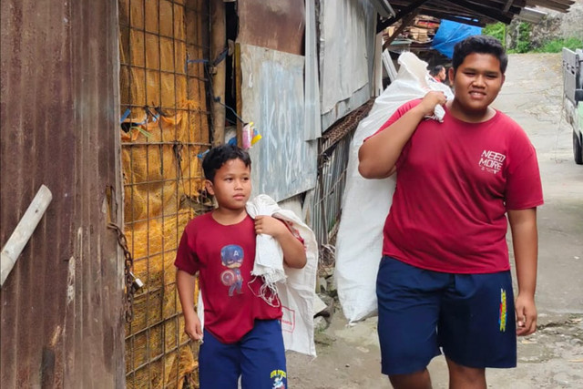 Juni Arta Dwi Prasetyo (16 tahun) bersama Rizki Tri Prasetyo (11 tahun) dua kakak beradik pencari rongsok di Kota Yogyakarta. Foto: Arfiansyah Panji Purnandaru/kumparan