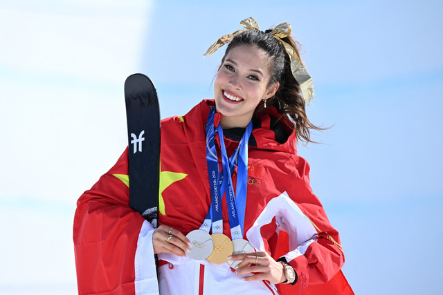 Peraih medali emas asal China, Gu Ailing Eileen, merayakan kemenangannya di podium setelah memenangkan final halfpipe ski gaya bebas putri pada Olimpiade Musim Dingin Milano Cortina 2026 di Livigno Snow Park, Livigno, Minggu (22/2/2026). Foto: Kirill Kudryavtsev/AFP