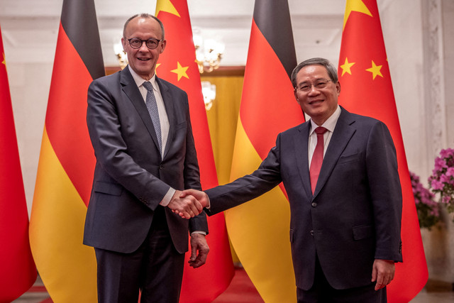 Perdana Menteri China Li Qiang berjabat tangan dengan Kanselir Jerman Friedrich Merz di Balai Besar Rakyat di Beijing, China, Rabu (25/2/2026). Foto:  Michael Kappeler/Pool via Reuters