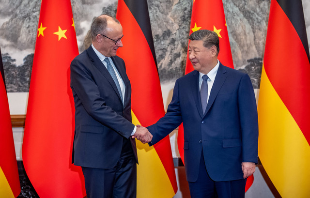 Kanselir Jerman Friedrich Merz berjabat tangan dengan Presiden China Xi Jinping di wisma tamu negara, di Beijing, China, Rabu (25/2/2026). Foto:  Michael Kappeler/Pool via Reuters