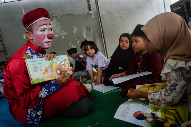 Badut syariah Yahya Edward (kiri) membaca buku cerita saat kegiatan dongeng Islami di Sudimara, Pinang, Kota Tangerang, Banten, Kamis (26/2/2026). Foto: Putra M. Akbar/ANTARA FOTO 