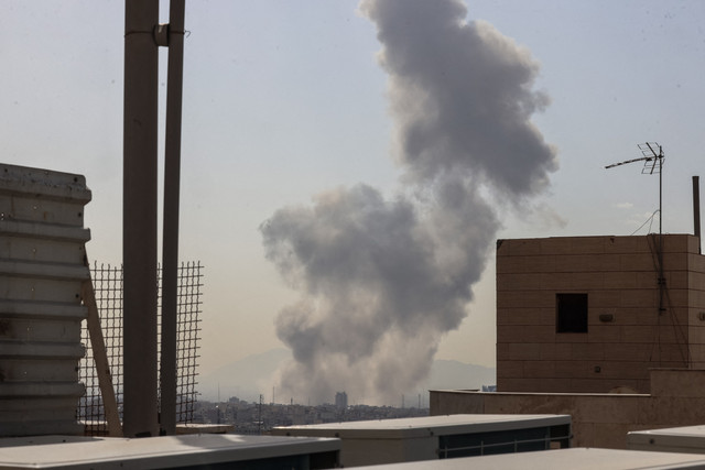 Kepulan asap membubung setelah ledakan yang dilaporkan terjadi di Teheran pada Sabtu, (28/2/2026). Foto: Atta Kenare/AFP