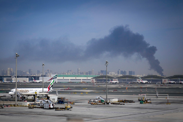 Kepulan asap yang disebabkan oleh serangan Iran terlihat di Bandara Internasional Dubai, Uni Emirat Arab, Minggu, (1/3/2026). Foto: AP Photo/Altaf Qadri