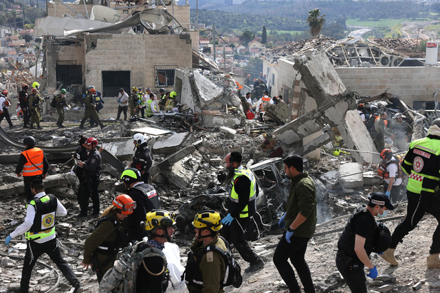 Layanan darurat Israel mengamankan lokasi serangan rudal di dekat Bet Shemesh, sekitar 30 kilometer sebelah barat Yerusalem pada 1 Maret 2026. Foto: Ahmad Gharabli / AFP