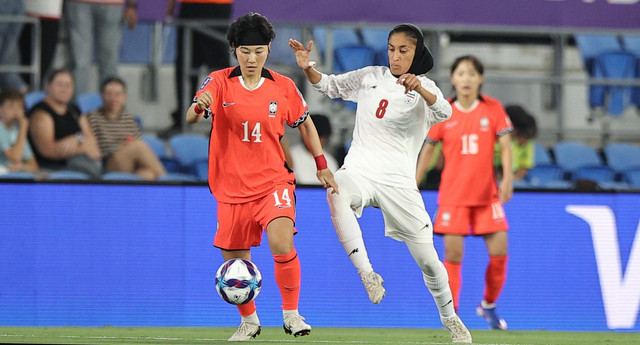 Pemain Korea Selatan, Jung Min-Youn, berduel dengan pemain Iran, Shabnam Behesit, dalam pertandingan Grup A Piala Asia Wanita 2026, Senin (2/3). Foto: AFC