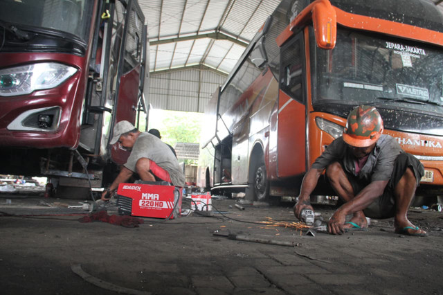 Teknisi melakukan perawatan armada bus PO Shantika di garasi pada Rabu (4/3). Foto: Vega Maarijil Ula/kumparan